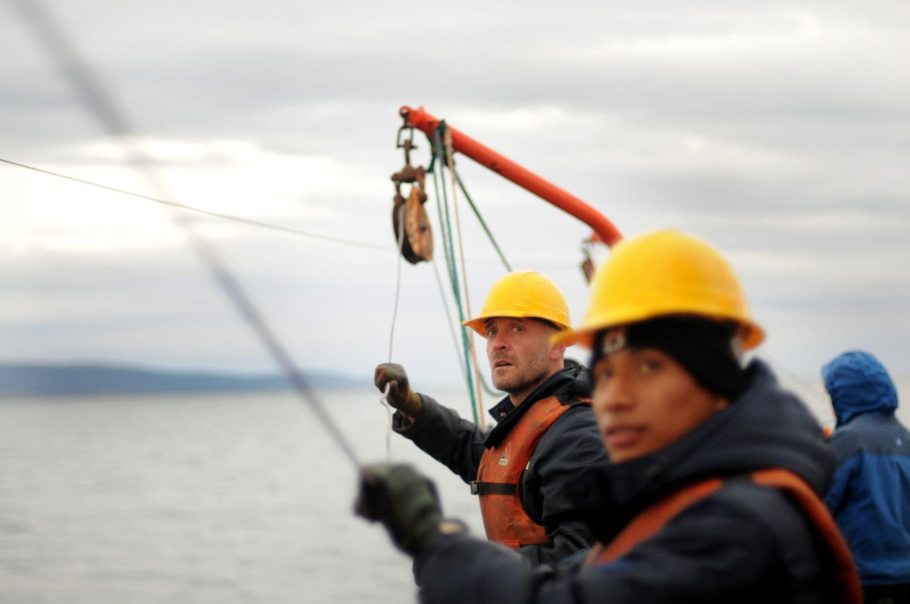 Crew in safety gear securing equipment on a vessel deck