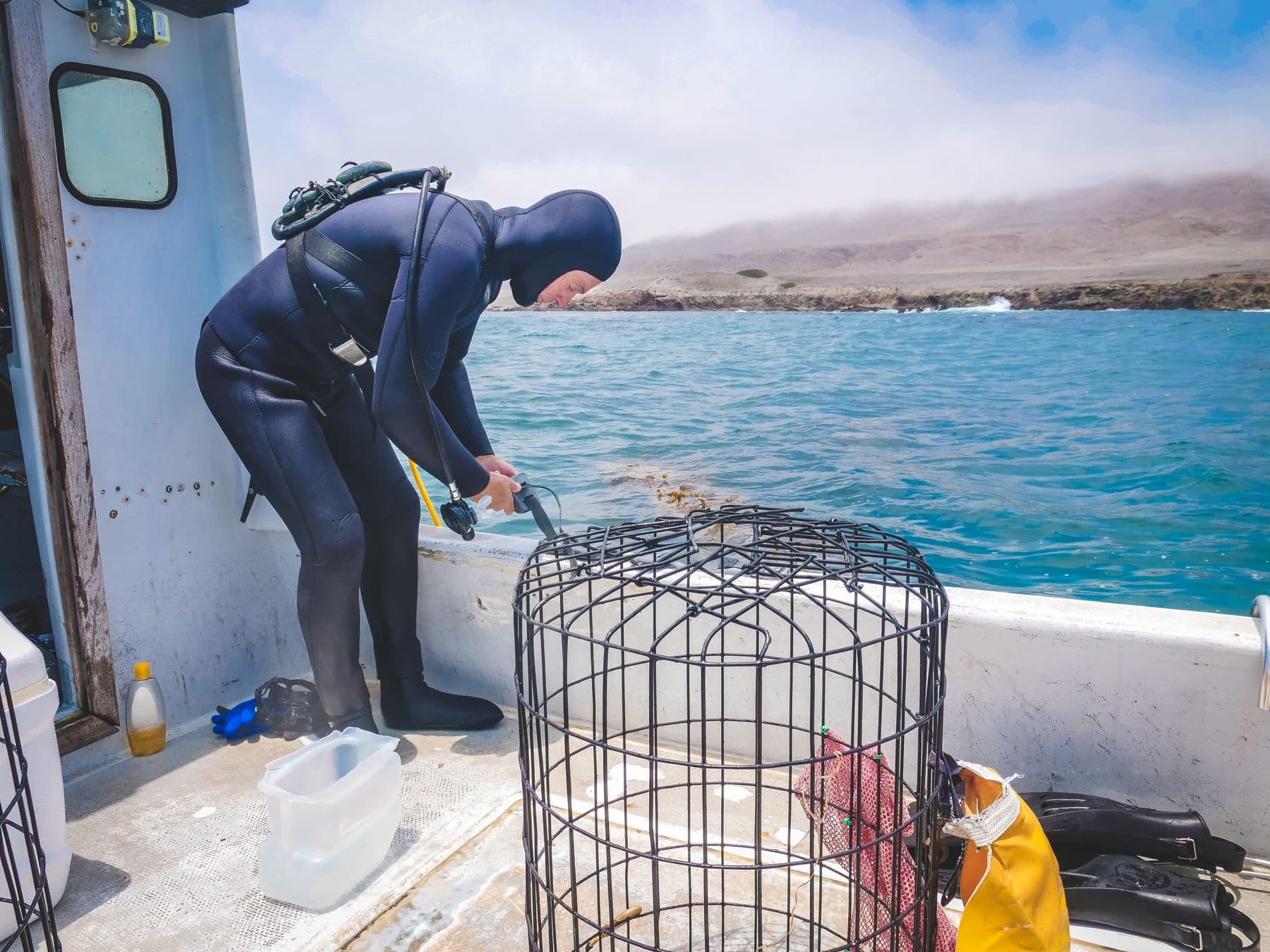 Diver checking equipment on the deck of a working boat