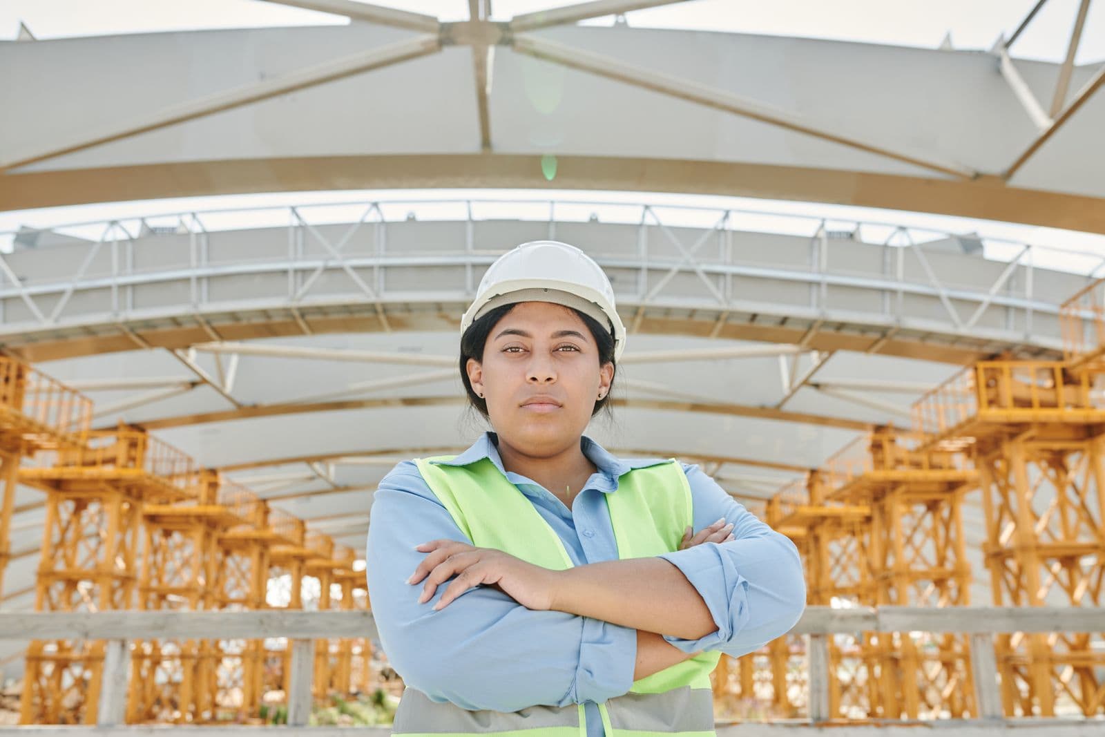 Engineer in safety gear on site beside a steel structure